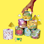 Stack of colourful wrapped toilet paper rolls with a hand arranging them on a yellow background