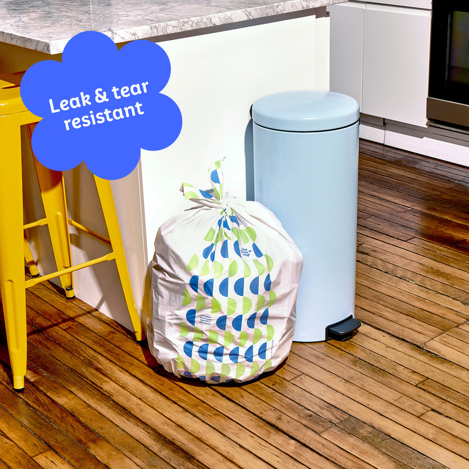 Who Gives a Crap large recycled trash bag sits full next to kitchen bin. Caption in corner reads ‘Leak & tear resistant’.