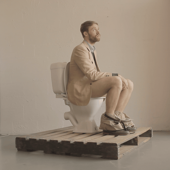 Simon Griffiths founder of Who Gives A Crap sitting on a toilet 